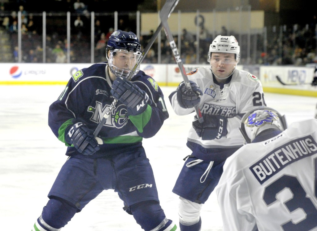 Maine's Jason Salvaggio, left, and Railers defenseman David Quenneville converge on a rebound of Salvaggio's shot on Worcester goalie Evan Buitenhuis during Sunday's game.