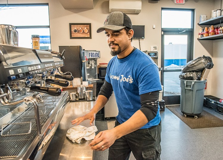 Tulio DeAlmeida cleans up after a busy day at Aroma Joe's in Auburn. He and his family worked so their employees could take Christmas Day off.