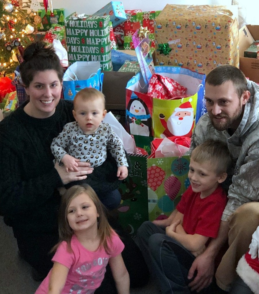 Chelsea Austin and Justin Jackson of Carthage, and their children, Quinn, Eloise and Brock, sit among gifts donated by people in the area after the family's home burned Dec. 21, in top photo.