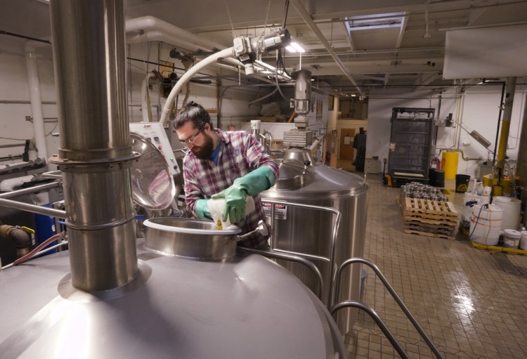 Brewer Mike O'Neal adds hops to a batch of Daymark on Tuesday at Rising Tide Brewing Co. in Portland. The partial government shutdown could cause some breweries to delay release of any new brew batches.