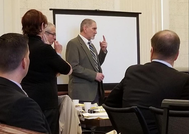 James Sweeney, center, formerly of Jay, signs an answer to a question from Justice William Stokes to an American Sign Language interpreter during his murder trial Friday in Franklin County Superior Court.