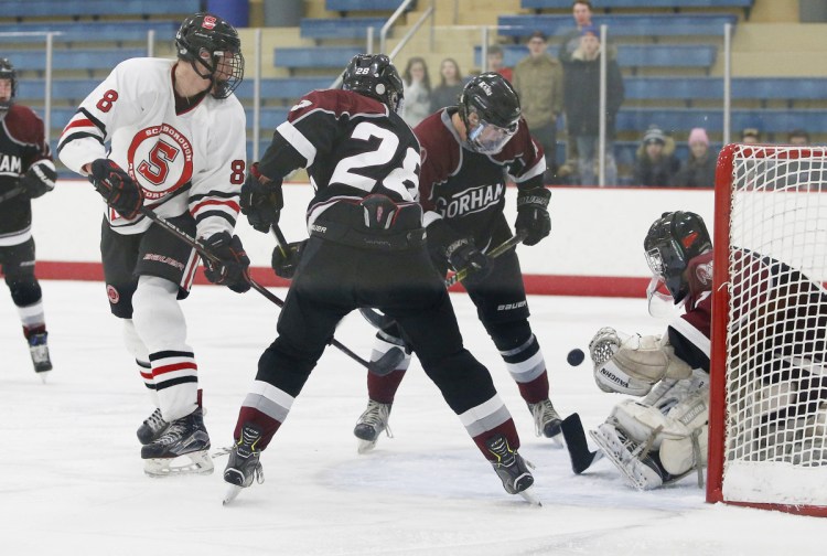 Gorham goalie Giuseppe Brown makes a save in front of Nolan Matthews of Scarborough as Trevor Gray, 28, and Cole Perreault defend in the second period Friday. Scarborough won, 2-1.