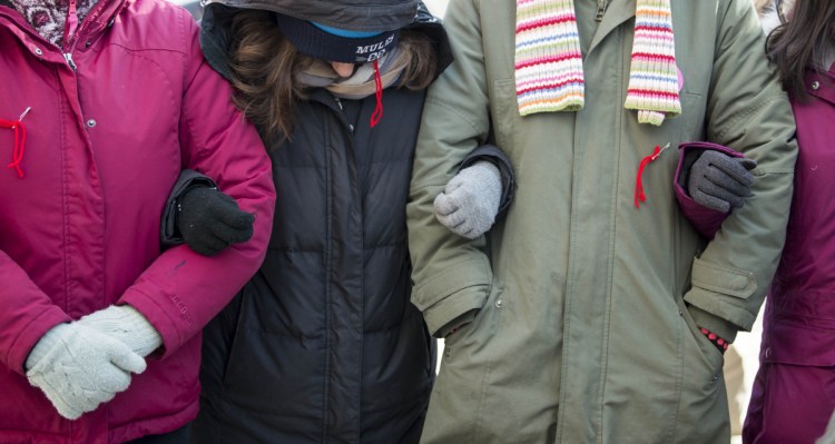 Women link arms for the Equality Rally outside Waterville City Hall. A topic of the day was Skowhegan High School's "Indians" nickname for sports teams.