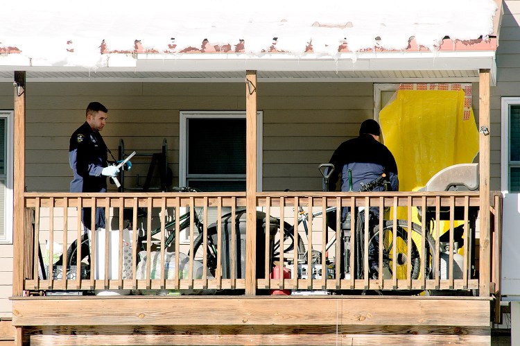 Maine State Police evidence technicians enter the apartment on Wednesday where a man and a woman were found dead in South Paris. Their children, a 2-month-old infant and an 8-year-old, were placed in the care of the Maine Department of Health and Human Services. 