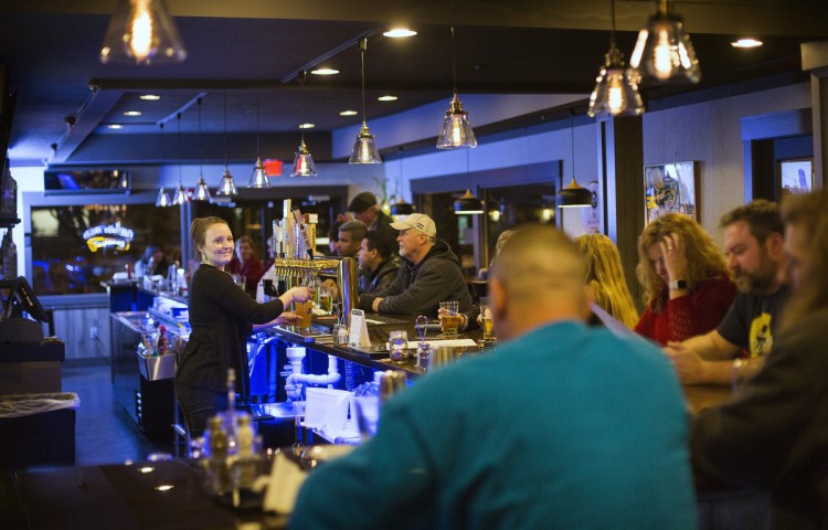 Crista Getchell serves pints to customers at Coppersmith Tavern & Table.