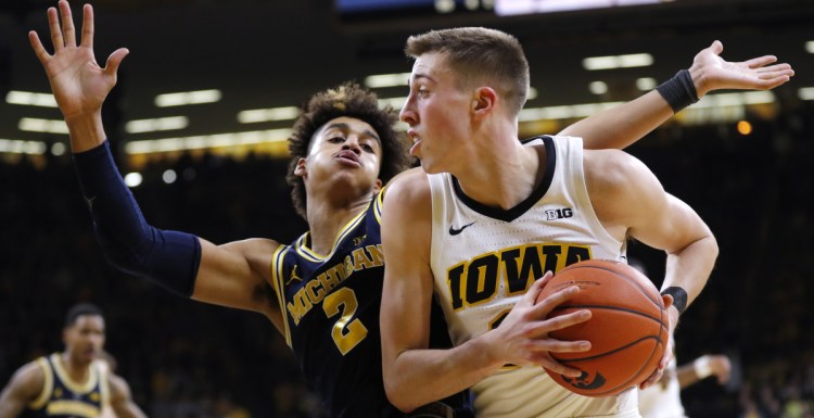 Iowa's Joe Wieskamp drives past Michigan's Jordan Poole in the second half Friday night at Iowa City, Iowa. Iowa upset fifth-ranked Michigan, 74-59.