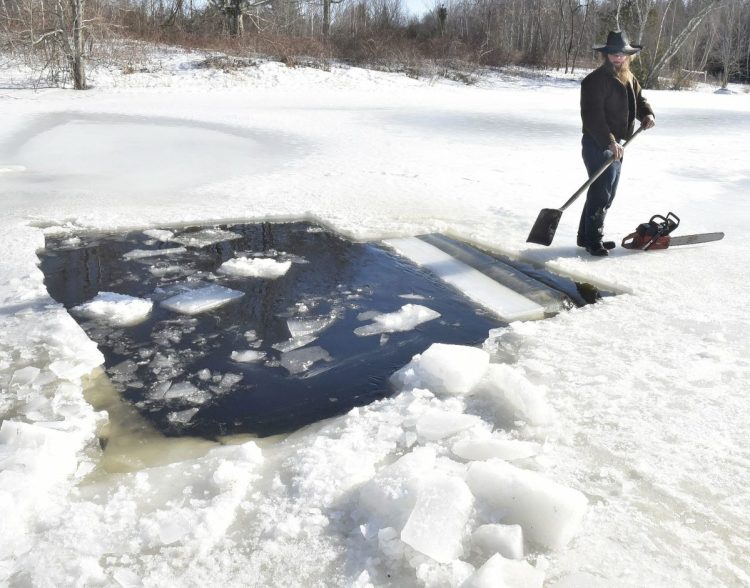 Amish farmer Isaac Hostetler separates with a shovel a large block of ice he cut from a pond at his farm in Palmyra on Wednesday. The ice will be used for an ice bar during Somerset SnowFest this weekend.