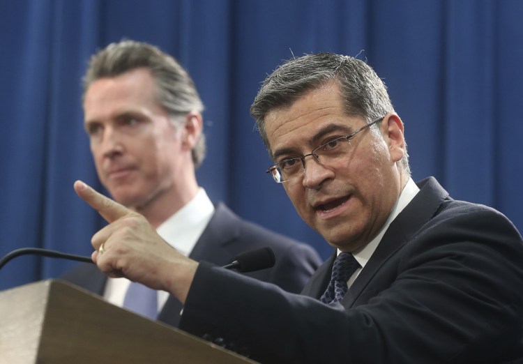 California Attorney General Xavier Becerra, right, accompanied by Gov. Gavin Newsom, said California will sue President Trump over his emergency declaration to fund a wall on the U.S.-Mexico border.