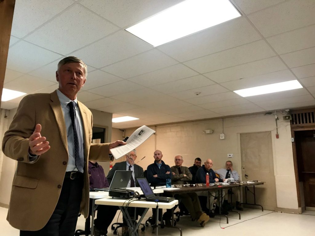 Morning Sentinel photo by Rachel Ohm 
 John Carroll, communications director for Central Maine Power, addresses the public and the Farmington Board of Selectmen, pictured in the background, during a board meeting Tuesday at the Farmington Community Center.