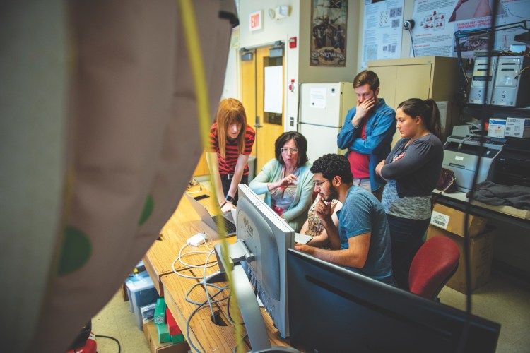 UMaine professor of psychology Marie Hayes, second from the left, in one of the weekly lab sessions with graduate student team members. Left to right, Chris Gilbert, Jessica Aronis (partially obscured) and Ahmed Almaghasilah (seated in foreground), Ryan Dufour and Ariel Bouchard.