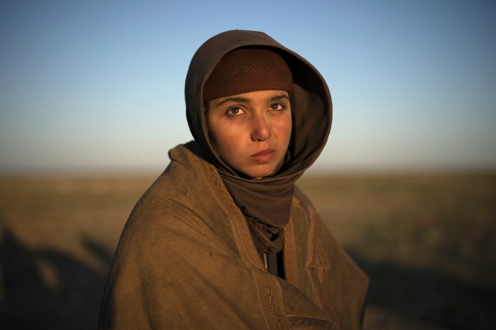 A girl waits to be screened by U.S.-backed Syrian Democratic Forces after being evacuated out of the last territory held by Islamic State militants in the desert outside Baghouz, Syria, on Friday.