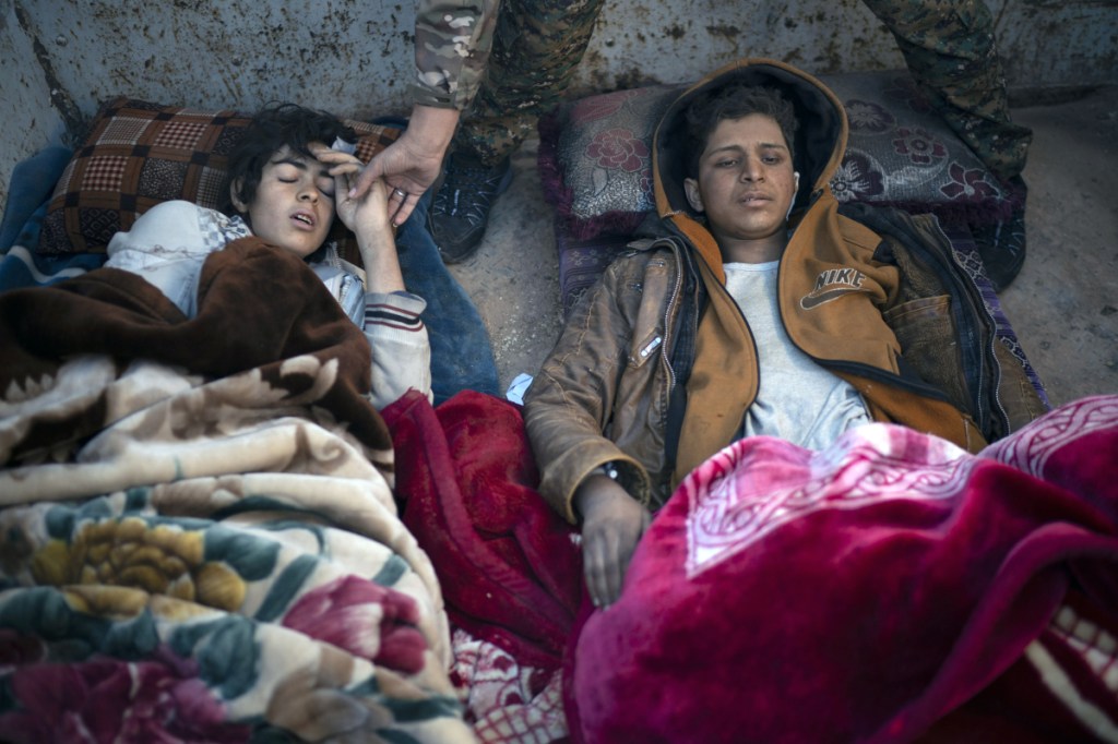 Two injured boys suspected of being Islamic State supporters lie on the back of a truck at a U.S.-backed Syrian Democratic Forces screening area after being evacuated out of the last territory held by Islamic State militants in the desert outside Baghouz, Syria, on Friday.