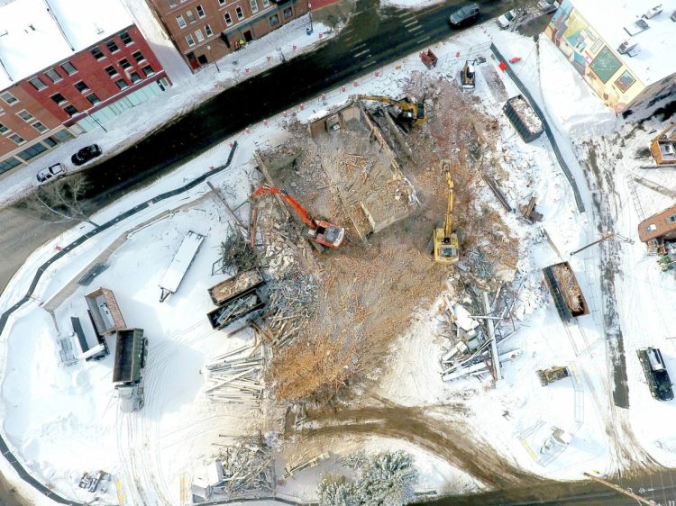 Excavator operators finish demolishing the former Camden National Bank in downtown Waterville in February to make room for the planned Colby College hotel at the end of Main Street.