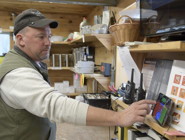 Kevin Bacon checks the flow of sap Sunday at his family's sugarbush at Bacon Farm Maple Products in Sidney. Radio monitors installed on sap lines send updates to electronic devices and his cellphone.