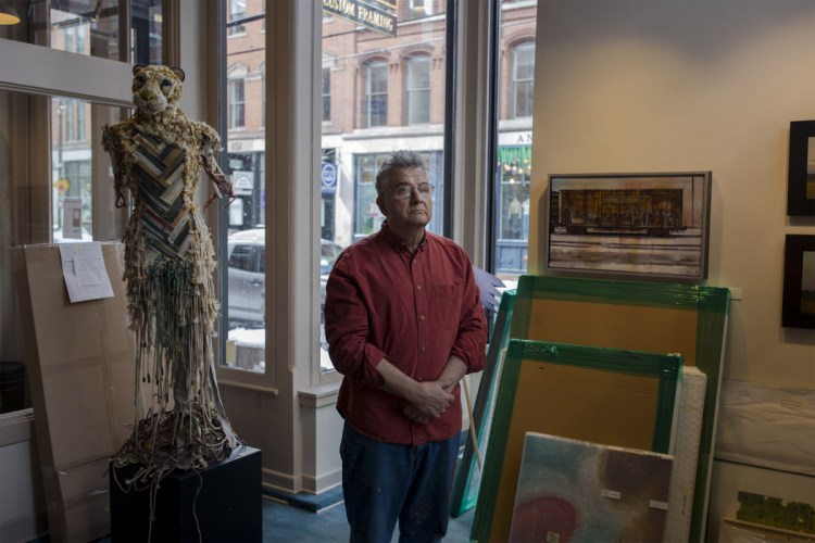 Portland artist Henry Isaacs watches as his exhibition, “Travel Notes,” is set up at Greenhut Galleries in Portland on March 4. The 68-year-old painter and his wife are heading to Nepal next week so that he can paint the world’s tallest peak.