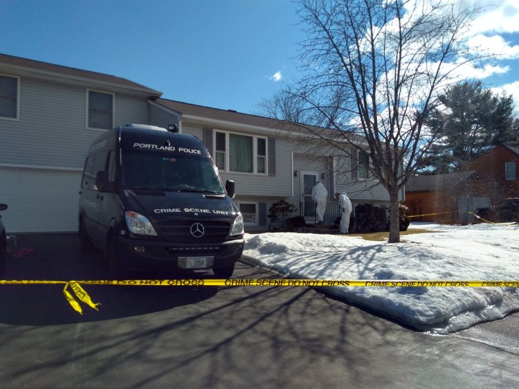 Investigators from the Portland police Crime Scene Unit on Sunday inspect the front of the house at 107 Milton St., where a 22-year-old man was shot and killed early Saturday.