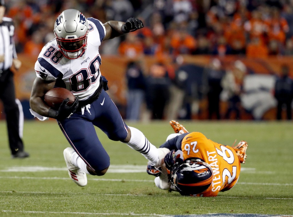 Tight end Martellus Bennett is tripped up by Broncos free safety Darian Stewart during a 2017 game in Denver. Bennett says he won't be coming out of retirement to rejoin the New England Patriots. (AP Photo/Jack Dempsey, File)