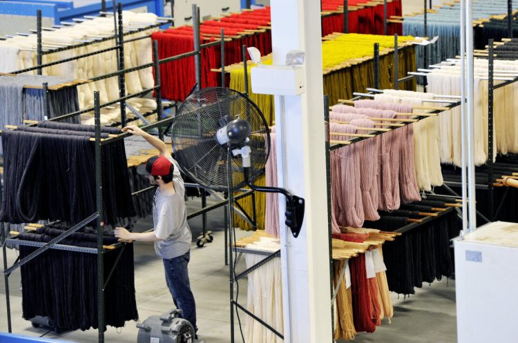 Lonny MacOrquodale hangs yarn to dry at the Saco River Dyehouse – now Maine Dye & Textiles –  in July 2016. A company expansion that year that led to financial problems.