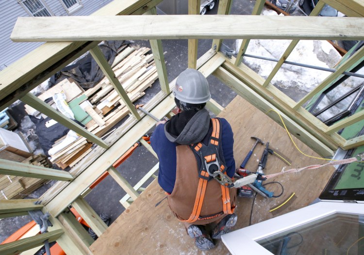 Carpenter Jay Nilsson lays decking on a balcony at Parris Terrace, a condominium building under construction in Bayside on Feb. 27.