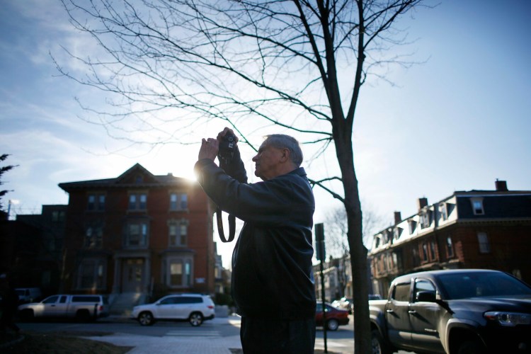 Ronald Perreault takes a photograph of the building where the car he was found in was parked on Deering Street in Portland. 

