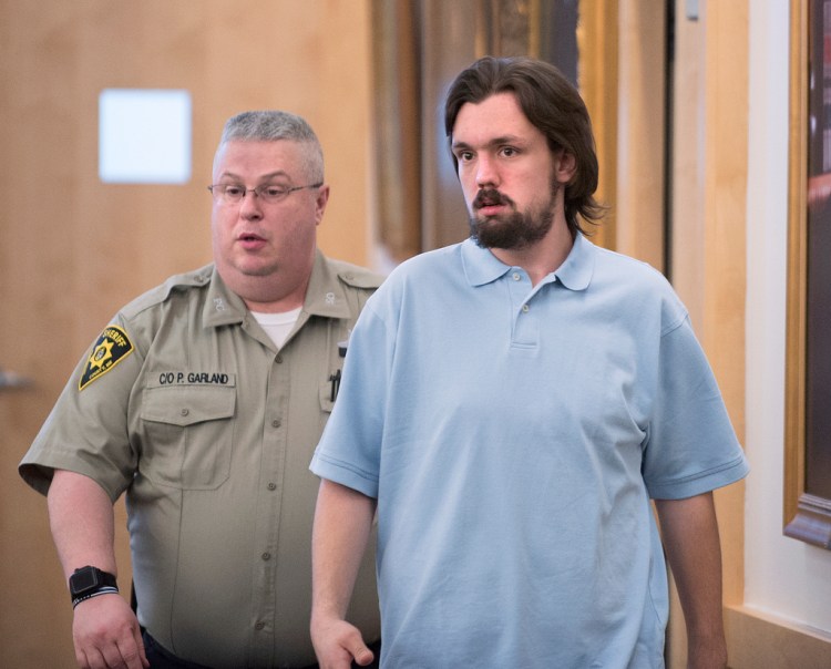 John De St. Croix is escorted into the courtroom at the Penobscot Judicial Center in Bangor in May. 