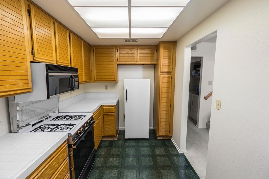 While this kitchen has dated features like panel lighting, decluttering simplifies and lightens the space.