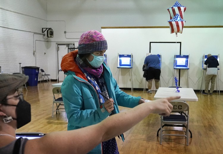 Monica Rojas gets directions from a poll worker on her way to casting her ballot at Sabathani Community Center on Tuesday in Minneapolis. If voters decide to replace the city police department, the new Department of Public Safety would take a “comprehensive public health approach to the delivery of functions” that “could include” police officers “if necessary, to fulfill its responsibilities for public safety.”