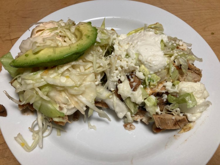 Two sopes - little corn dough bowls filled with assorted goodies - from Taco Trio. Pictured are a pescado chipotle sope, with beer-battered fish, and a pollo con mole sope, featuring chicken in mole sauce. 