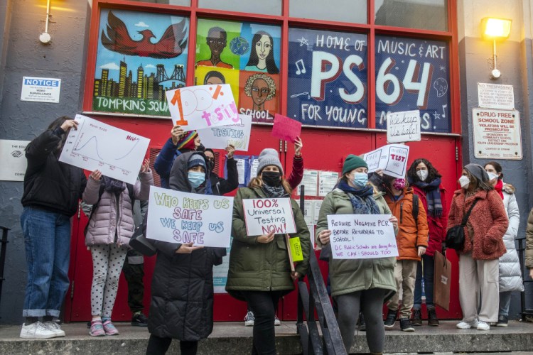 Teachers from the Earth School speak out on issues related to lack of coronavirus testing outside P.S. 64, on Dec. 21 in New York.