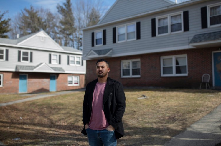 Kevin Ly in front of his childhood home in Riverton Park in Portland. Ly, a founder of the new Massachusetts-based company Golden Wat Spirits, is donating the profits from his Maine sales to Full Plates, Full Potential. Ly said he was grateful for subsidized meal programs that operated in the neighborhood when he was growing up. 