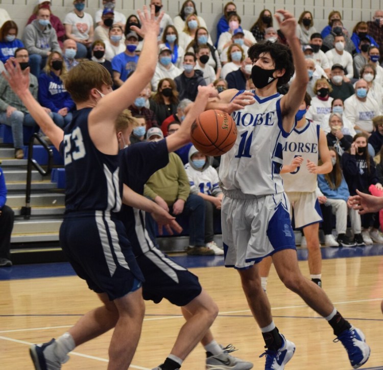 Morse’s Andrew Card (11) is fouled by Westbrook’s Conner Doolittle (11) and Micah Lombardo (23) during a Class A South prelim game last season in Bath.