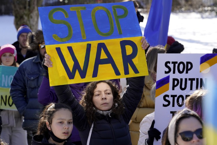 Demonstrators display placards during rally Sunday in support of Ukraine, in Boston.