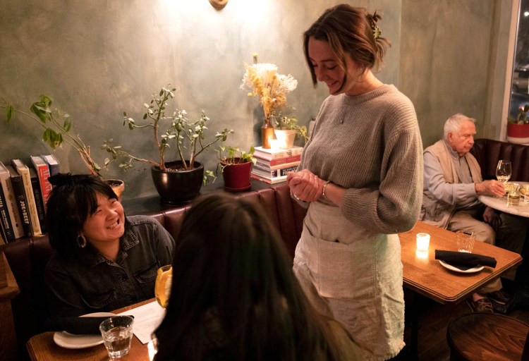 Wayside Tavern server/bartender Katie PriorTavern, talks with customers, Mia Bogyo, far left, while she dines at the restaurant in early February.