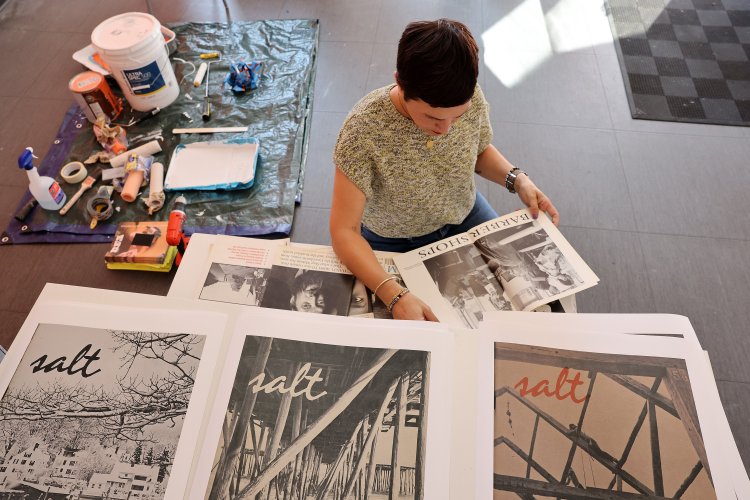 Mira Ptacin, an alumna of the Salt Institute of Documentary Studies, flips through a copy of Salt magazine at Maine College of Art's 49 Oak Gallery, which will host an exhibit on Salt's 50th anniversary this month. 